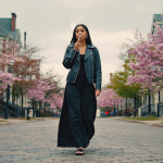 Adults relaxing on an Atlanta balcony at sunset, with cannabis and mushroom products visible, and city skyline in the background.