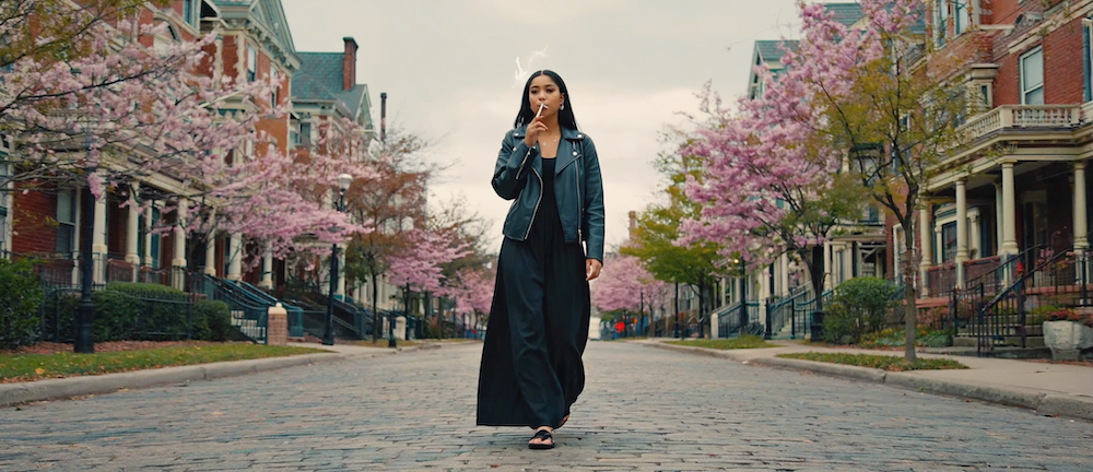Adults relaxing on an Atlanta balcony at sunset, with cannabis and mushroom products visible, and city skyline in the background.